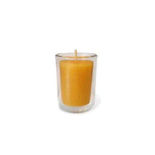 Beeswax votive candle in clear glass holder.