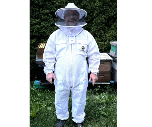 Beekeeper wearing ventilated beekeeping suit with detachable veil, standing near hives.