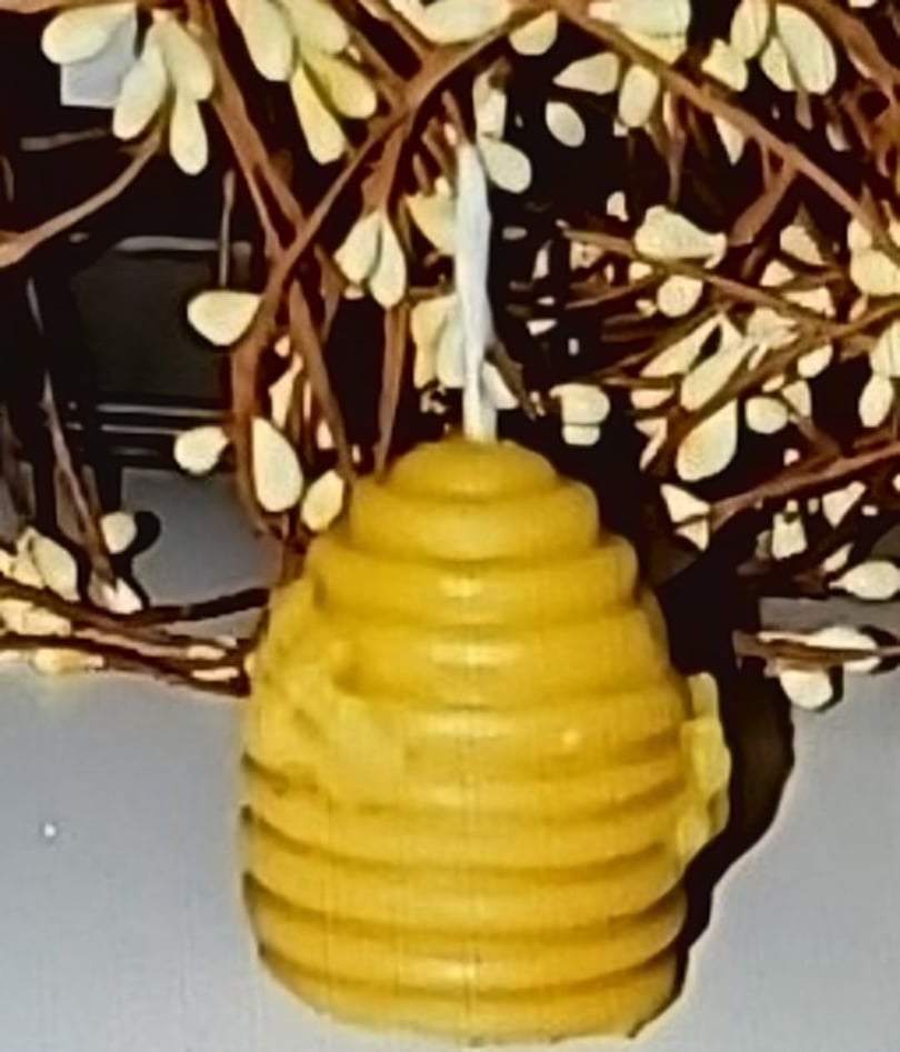 Beeswax hive candle mini in tea light size with a natural scent, shaped like a beehive.